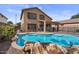Inviting backyard with rock waterfall pool, covered patio, and secure fencing for relaxation and privacy at 4323 E Dublin St, Gilbert, AZ 85295