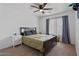 Bedroom with a queen bed, nightstand, ceiling fan, window with blinds, and carpeted floor at 4323 E Dublin St, Gilbert, AZ 85295