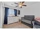 Cozy bedroom with a dark grey crib, white dresser, ceiling fan, and natural light at 4323 E Dublin St, Gilbert, AZ 85295