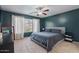 Bedroom with dark accent wall, window, ceiling fan, queen bed, carpeted floors, and bedside table at 4323 E Dublin St, Gilbert, AZ 85295