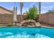 Resort-style backyard pool with rock features, lush landscaping, and relaxing ambience at 4323 E Dublin St, Gilbert, AZ 85295