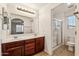 Well-lit bathroom with double sinks, wood cabinets, a large mirror, and a glass-enclosed shower at 4380 E Renee Dr, Phoenix, AZ 85050