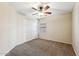 Neutral bedroom features a ceiling fan, window, and closet with sliding doors at 4380 E Renee Dr, Phoenix, AZ 85050