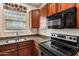 Close-up of a kitchen with granite countertops, wooden cabinets, and stainless steel appliances at 4380 E Renee Dr, Phoenix, AZ 85050