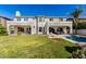 Expansive backyard features a covered patio, lush lawn, pool, and a charming two-story home at 4497 E Carriage Way, Gilbert, AZ 85297