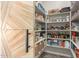 Walk-in pantry with custom barn door and ample shelving for organized storage at 4497 E Carriage Way, Gilbert, AZ 85297