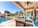 Covered patio featuring plush outdoor seating, a fire pit, and views of the pool and yard at 4497 E Carriage Way, Gilbert, AZ 85297