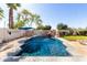 Private backyard pool with a rock waterfall feature and turquoise umbrella at 4497 E Carriage Way, Gilbert, AZ 85297