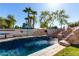 Sparkling pool with waterfall feature surrounded by lush landscaping and patio at 4497 E Carriage Way, Gilbert, AZ 85297