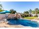 Inviting pool with rock waterfall and lush landscaping, perfect for outdoor relaxation at 4497 E Carriage Way, Gilbert, AZ 85297
