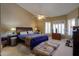 Comfortable bedroom showcasing neutral tones, carpet, ceiling fan and a window with plantation shutters at 4560 E Paso Trl, Phoenix, AZ 85050
