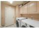 Bright laundry room featuring a side-by-side washer and dryer and storage cabinets at 4560 E Paso Trl, Phoenix, AZ 85050