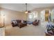 Spacious living room with leather furniture, ceiling fan, and access to kitchen at 4560 E Paso Trl, Phoenix, AZ 85050