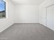 Bright bedroom features a large window, plush carpet, and a spacious closet at 5501 W Whispering Wind Dr, Glendale, AZ 85310