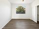 Empty bedroom with hardwood floors, a window overlooking trees and a closet with sliding doors at 5501 W Whispering Wind Dr, Glendale, AZ 85310