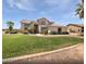 Two-story home boasts lush green lawn, mature trees, and well-maintained landscaping at 5501 W Whispering Wind Dr, Glendale, AZ 85310