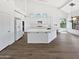 Modern kitchen with white cabinets and large island great for entertaining with luxury vinyl flooring at 5501 W Whispering Wind Dr, Glendale, AZ 85310