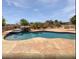 Beautiful backyard pool features rock waterfall, outdoor kitchen, and plenty of room for lounging at 5501 W Whispering Wind Dr, Glendale, AZ 85310