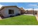 Private backyard with a well-maintained lawn, a covered patio, and a block wall for seclusion at 5526 W Ellis Dr, Laveen, AZ 85339