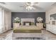 Well-lit bedroom with a decorative rug, stylish furnishings, a ceiling fan, and a grey accent wall at 5526 W Ellis Dr, Laveen, AZ 85339