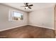 Relaxing bedroom features wood floors, ceiling fan, and a window offering natural light at 5627 E Covina Rd, Mesa, AZ 85205
