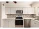 Modern kitchen featuring white cabinets, stainless steel appliances, and stylish mosaic backsplash at 5627 E Covina Rd, Mesa, AZ 85205