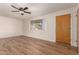 Bright living room featuring wood-look floors, ceiling fan, and large windows at 5627 E Covina Rd, Mesa, AZ 85205