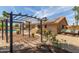Backyard featuring a pergola, outdoor fireplace, and desert landscaping with solar panels on the roof of the home at 6073 E Beck Ln, Scottsdale, AZ 85254