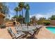 A charming patio area featuring a table with an umbrella, ideal for outdoor dining and gatherings in a lush backyard at 6073 E Beck Ln, Scottsdale, AZ 85254
