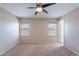 Spacious carpeted bedroom with ceiling fan and two windows with bamboo blinds at 645 W Kingman Loop, Casa Grande, AZ 85122