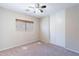 This carpeted bedroom features a ceiling fan, window with blinds, and closet at 645 W Kingman Loop, Casa Grande, AZ 85122