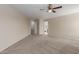Bright primary bedroom with carpet, neutral walls, a ceiling fan, and access to the closet and bathroom at 681 W Racine Loop, Casa Grande, AZ 85122