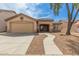 Charming single-story home with a two-car garage, desert landscaping, and a curved walkway to the front door at 681 W Racine Loop, Casa Grande, AZ 85122