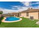 Beautiful backyard pool area with artificial turf and blue water under a partly cloudy sky at 681 W Racine Loop, Casa Grande, AZ 85122