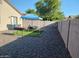 Gravel backyard features a BBQ, seating area with a blue awning, and privacy walls at 7118 S 37Th Gln, Phoenix, AZ 85041