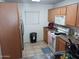 Functional kitchen with wood cabinets, a white range, and stainless steel refrigerator at 7118 S 37Th Gln, Phoenix, AZ 85041