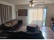 View of living room with sliding glass door to patio, ceiling fan, and tile flooring at 7118 S 37Th Gln, Phoenix, AZ 85041