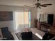 View of living room with sliding glass door to patio, ceiling fan, and tile flooring at 7118 S 37Th Gln, Phoenix, AZ 85041