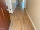Hallway featuring light brown wood-look tile flooring throughout, and neutral tan wall paint at 7243 E Cattle Call St, San Tan Valley, AZ 85143