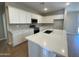 Bright kitchen featuring white cabinets, gray backsplash, stainless appliances, an island and quartz countertops at 7243 E Cattle Call St, San Tan Valley, AZ 85143
