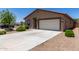 Home featuring a two-car garage, low-maintenance desert landscaping, and a long driveway for additional parking at 8012 S Magic Dr, Casa Grande, AZ 85193