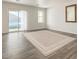 A bright room with wood-look floors, sliding glass doors with curtains, and a neutral rug and paint at 8012 S Magic Dr, Casa Grande, AZ 85193