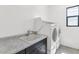 Bright laundry room featuring white appliances, sleek marble counters, and a window for natural light at 812 E Summerside Rd, Phoenix, AZ 85042