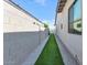 A narrow side yard with artificial turf, gravel, and a block wall, showcasing low-maintenance landscaping at 812 E Summerside Rd, Phoenix, AZ 85042