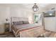 Cozy bedroom with a decorative light fixture, stylish patterned bedding, and a bright window at 8787 E Mountain View Rd # 2100, Scottsdale, AZ 85258
