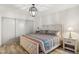Bright bedroom featuring a decorative light fixture, stylish patterned bedding, and wood-look flooring at 8787 E Mountain View Rd # 2100, Scottsdale, AZ 85258