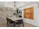 Dining room featuring a modern chandelier, brick accent wall, and laminate wood flooring at 8787 E Mountain View Rd # 2100, Scottsdale, AZ 85258