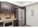 Charming kitchen featuring dark wood cabinetry, stainless steel appliances, and beautiful granite countertops at 8787 E Mountain View Rd # 2100, Scottsdale, AZ 85258