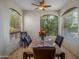 Bright dining room with large windows, ceiling fan, and a table set with flowers, perfect for Gathering meals at 9878 N 79Th Pl, Scottsdale, AZ 85258