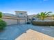 Charming home exterior features a spacious three-car garage, a well-maintained driveway, and lush tropical landscaping at 9878 N 79Th Pl, Scottsdale, AZ 85258